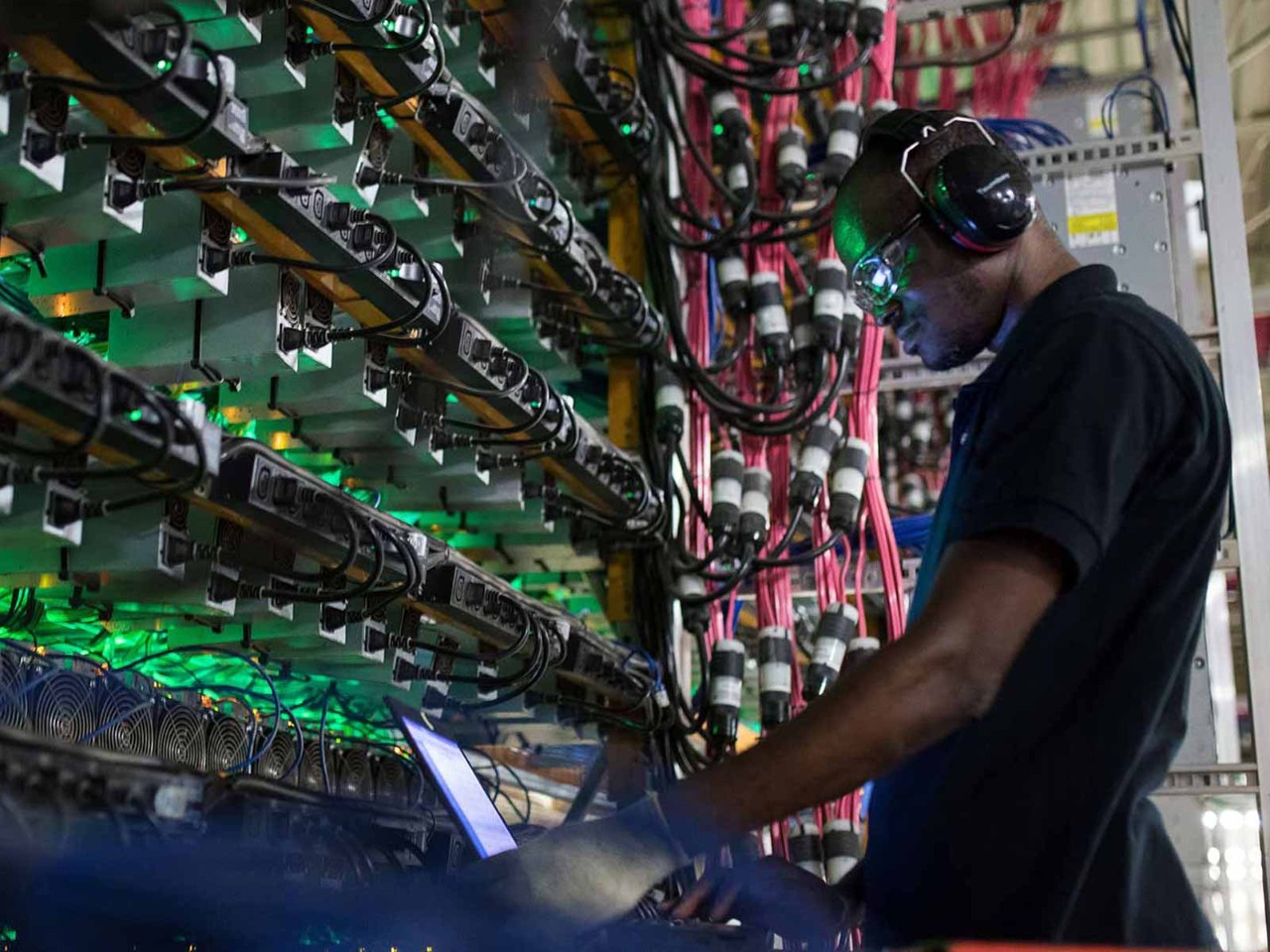 A technician monitors cryptocurrency mining rigs at a Bitfarms facility in Canada.